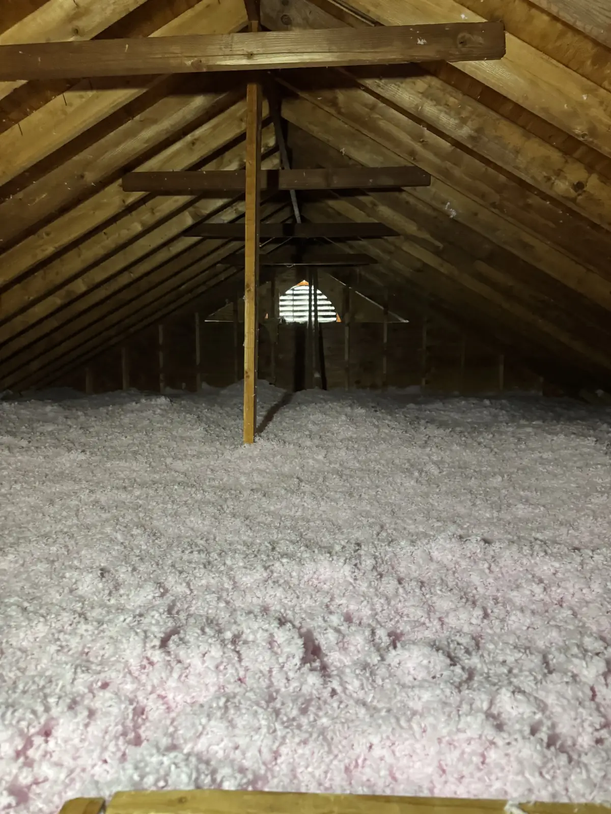 The same attic covered in an even layer of new pink insulation