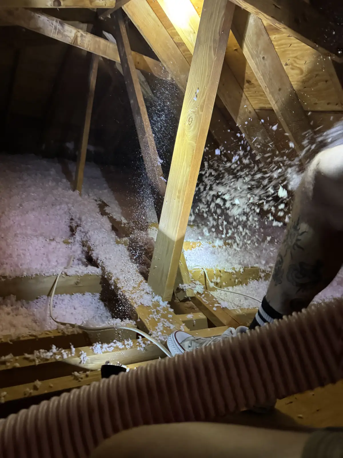 New pink insulation being blown in between the attic joists